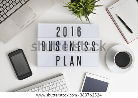 2016 business plan on office table with computer, coffee, notepad, smartphone and digital tablet