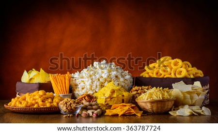 Different types of snacks, chips, nuts and popcorn in still life Royalty-Free Stock Photo #363787724