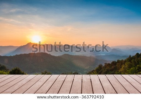 Wood table top on Majestic sunset in the mountains landscape background can put or montage your products