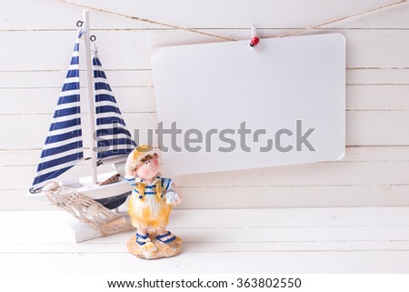 Decorative sailing boat and   empty tag on clothes line on wooden background. Selective focus. Place for text.