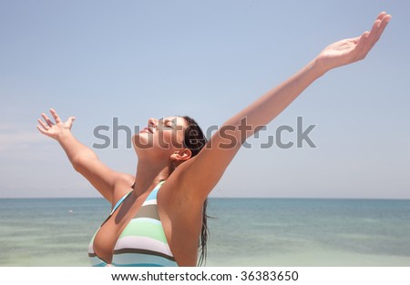 Relaxed woman with arms outstretched at the beach
