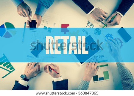 Business team working on desk with RETAIL word