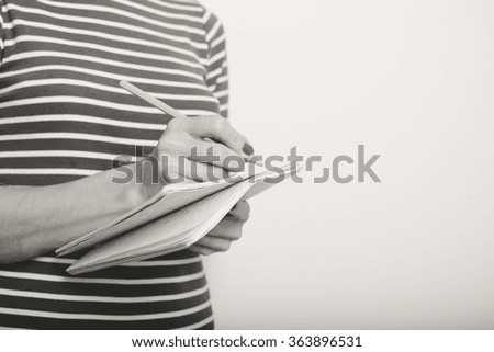 Black and white closeup picture of woman holding alarm clock over white background