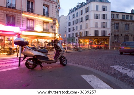 The streets of Paris are still full of activity, lit by neon advertisements, signs and billboards; people lingering on the terraces and cars rushing by. Nightlife in Montmartre