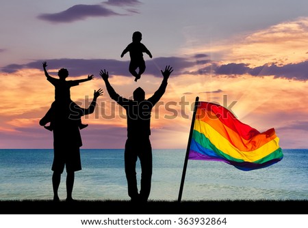 Concept of gay parents. Silhouette of happy gay parents with children on the background of sea sunset and a rainbow flag