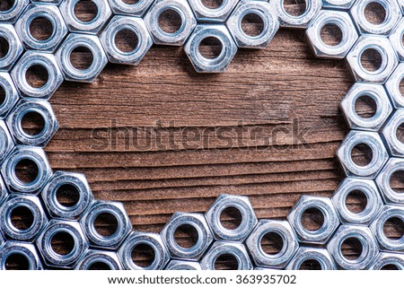 Chrome nuts on wooden background