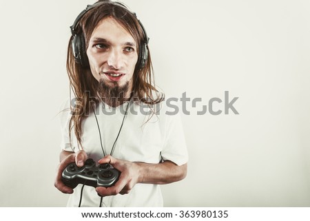 Playing games. Young smiling cheerful man play on console xbox playstation. Guy with pad joystick. Royalty-Free Stock Photo #363980135