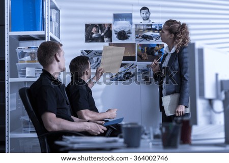 Horizontal view of police officers searching files