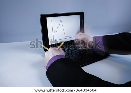 Leader beats a laptop. The displayed result line indicates the large reduction in income. Photographed long exposure, so that the right-hand movement is obtained by photo. Image includes a effect.