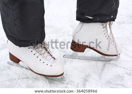 skate boots on teen girl feet close up photo on the skating rink ice