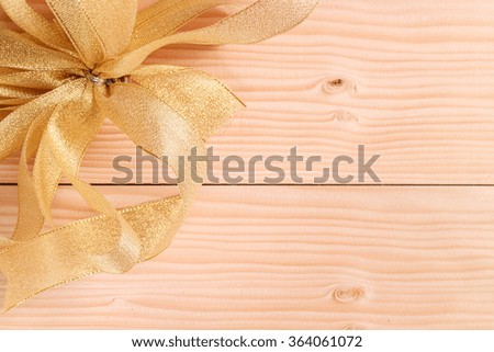 gold ribbon on wooden background with copy space