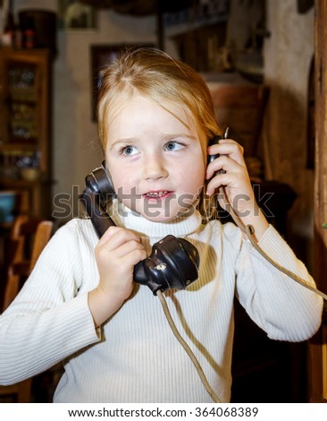 Cute preschooler girl talking by old vintage retro telephon, closeup portrait
