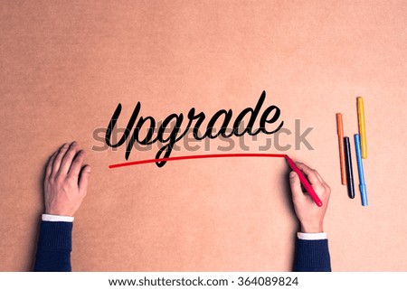 Hand writing a single word Upgrade on paper