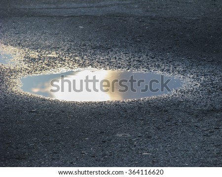 A puddle of water. The sun was intercepted from the eyes by cloud. Royalty-Free Stock Photo #364116620
