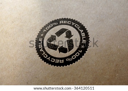 Recycle logo letterpressed and hot stamped on recycled paper background.