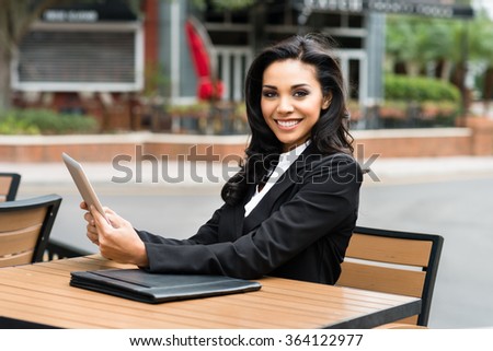 Young Hispanic businesswoman in her twenties outdoors working