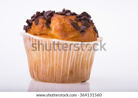 Delicious sweet dessert cupcake in paper basket with chocolate chips fattening food tasty baked refreshment isolated on white background closeup, horizontal picture