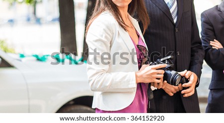 Pretty young woman  with  camera in city 