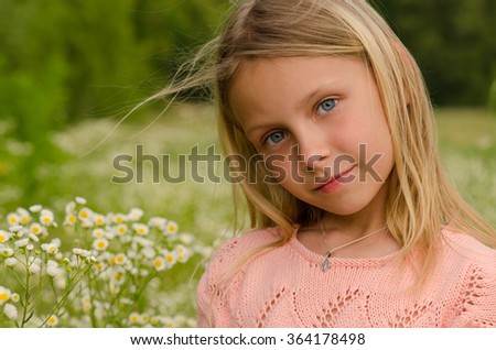 Beautiful girl on field of flowers on summer time