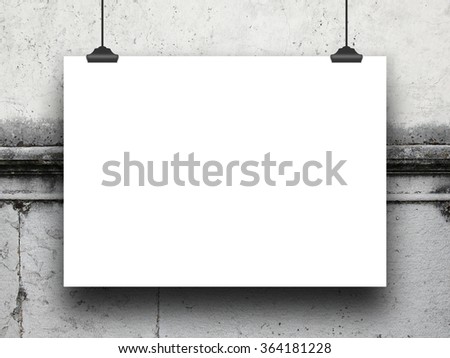 Close-up of one hanged poster with clips on damaged grey wall background