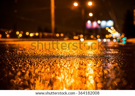 Rainy night in the big city, empty highway. View from the level of asphalt