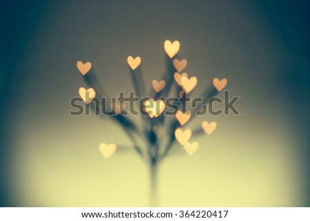 Unfocused background of Valentine tree with bokeh in hearts shape.