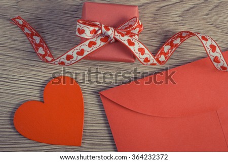 Vintage photo, Wrapped gift with ribbon, red wooden heart and love letter in envelope on wooden background, decoration for Valentines Day, copy space for text