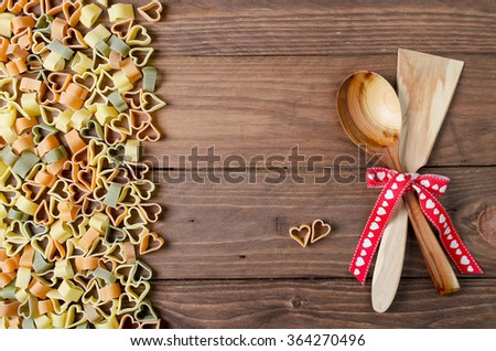 Cooking with love. Pasta hearts on wooden background. Valentine's day background