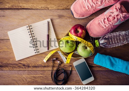 fitness concept with Exercise Equipment on wooden background. Royalty-Free Stock Photo #364284320