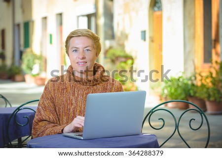 Young blond woman freelancer working outside on tabele