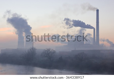 Smoking industrial chimneys at dawn. Concept for environmental protection Royalty-Free Stock Photo #364338917
