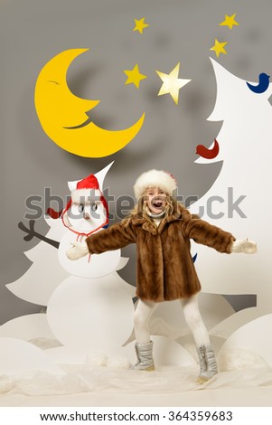 Joyful little girl in a cartoon fairy snowy forest. The magic of Christmas night. Full length portrait.