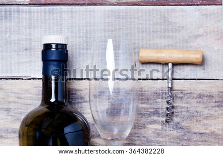 Corkscrew wine bottle and glass on the wooden table.toned
