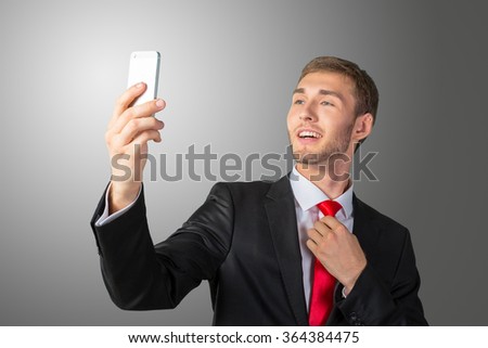 Handsome young businessman taking a selfie with a mobile phone