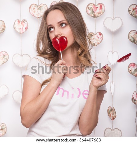 Valentines Day. Funny beautiful Woman holding candy in the form of heart