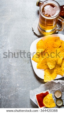 Beer background . Beer with chips and ketchup. On old stone background.