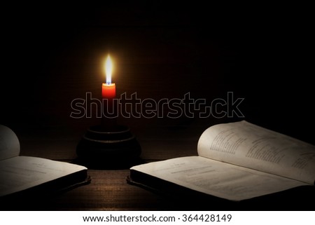 Lighted Candle And Two Open Books On The Rough Wood Horizontal Background With Copy Space