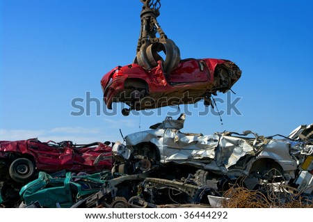 Crane picking up a car in a junkyard Royalty-Free Stock Photo #36444292