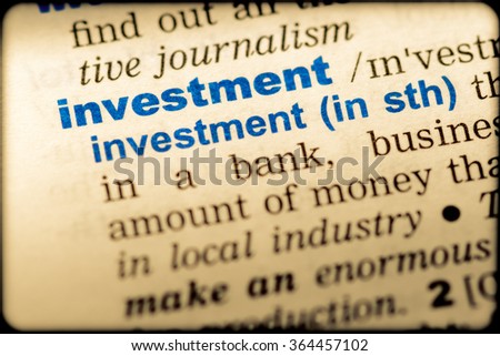 Close-up of word in English dictionary. Investment, definition and transcription