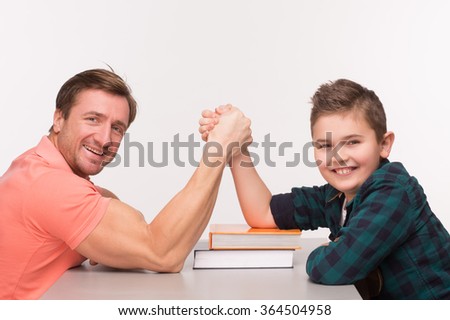 Young man and his son arm wrestling