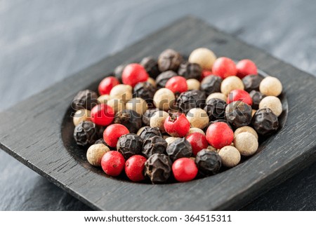 Close up medley trio colorful peppercorn in wooden spoon on stone background