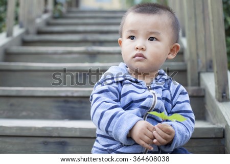 Cute Chinese baby boy playing outdoors, shot in Beijing, China