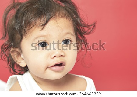 Portrait of one year old baby red background