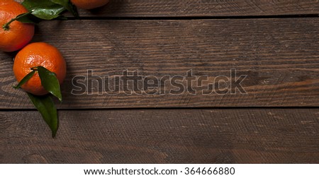 Photo of fresh mandarins on old brown wooden table