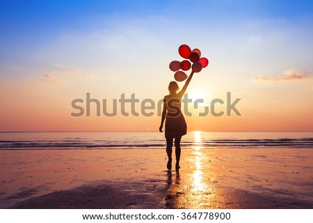 motivation or hope concept, follow your dream and inspiration, girl with balloons at sunset Royalty-Free Stock Photo #364778900