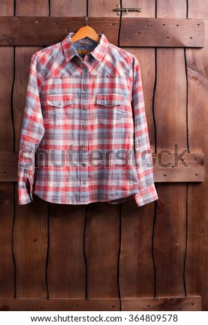 Fitting room in a clothing store. Shirt is hanging on a wooden fence.