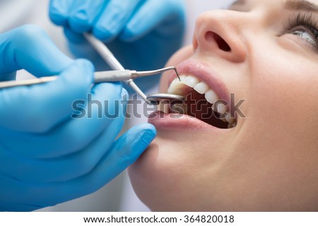 Dentist examining a patient's teeth in the dentist. Royalty-Free Stock Photo #364820018
