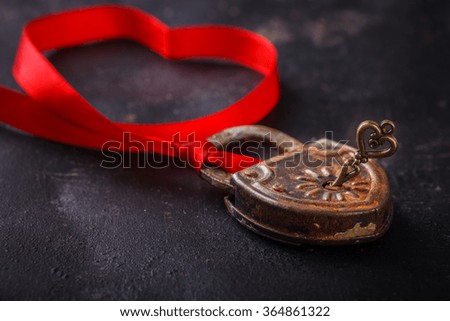 Padlock with key and a red ribbon ,the symbol of love.The background to the Valentine's day.selective focus.