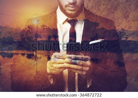 Planning his vacation. Digitally composed picture of young businessman holding his smart phone over the picture of landscape with palm trees