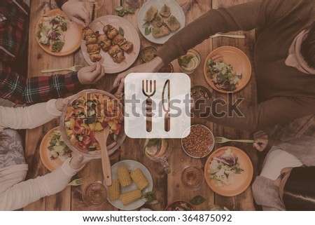 Perfect dinner. Digitally composed picture of kitchen utensil over top view of four people having dinner together while sitting at the rustic wooden table